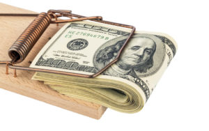 Image of cash stuck in a mouse trap to illustrate a cash crunch.