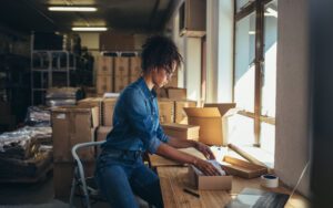 Business person packaging an item for shipping to illustrate e-commerce KPIs.