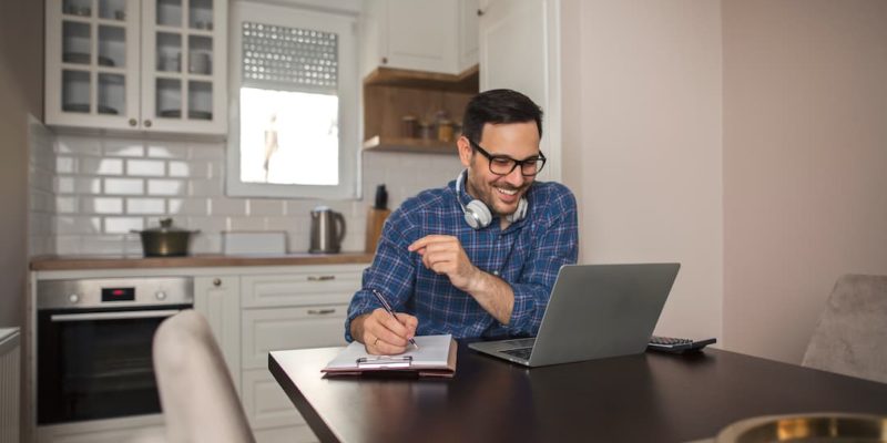 Person working from home to illustrate title of "Why Do Companies Choose to Outsource Work."