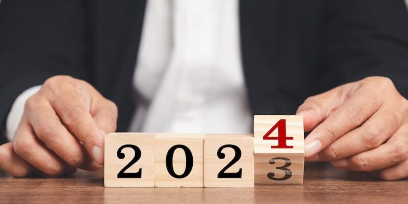 Business person turning blocks from showing 2023 to 2024 to illustrate a blog post about business trends 2024.