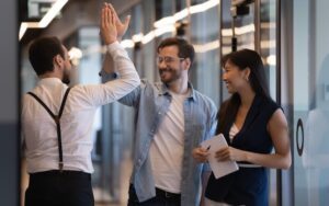 Coworkers high-fiving to illustrate a positive workplace culture.