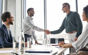 Professionals shaking hands to illustrate a blog post discussing how to hire fractional CFO services for SaaS companies.