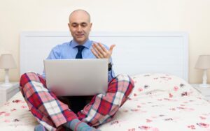 Person with business attire on top and pajamas on the bottom to illustrate a discussion about remote work in a blog about 2026 business trends.