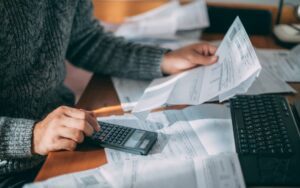 Person looking at receipts and adding up costs to illustrate a blog post about business trends in 2026.